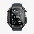 ACS11414 - Straight-on front view of Spigen Rugged Armor Apple Watch Ultra case displaying Rugged Armor and Shock Resist engravings with carbon fiber accents