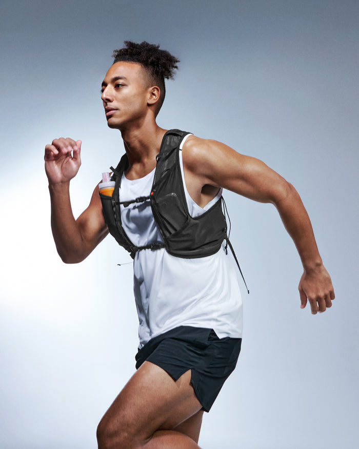 AMP10224 - Dynamic Shield™ Running Vest | A721 M-L in Black worn by a runner in motion with a soft flask stored in the front pocket.