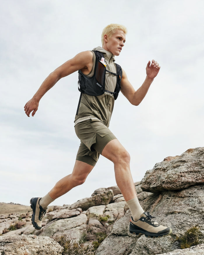 AMP10224 - Dynamic Shield™ Running Vest | A721 M-L in Black worn by a runner climbing rocky terrain outdoors.