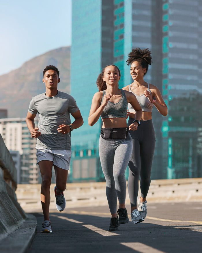 AMP04618 - Dynamic Shield™ Running Waistpack in black showing 3 people running with waistpack on