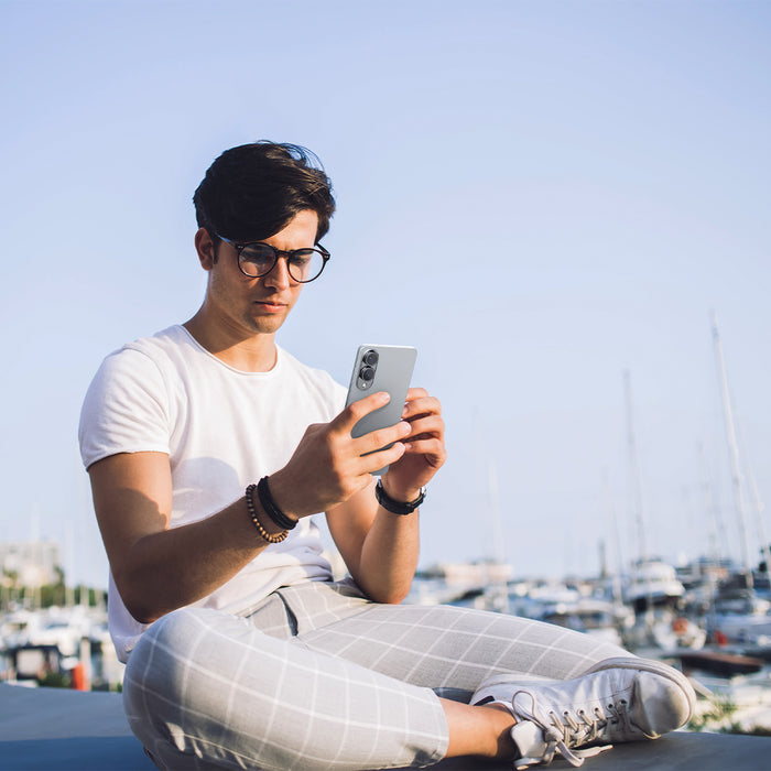 AGL09412 - Galaxy S25 Edge Optik EZ Fit Lens Pro Protector in Black showing the a man holding the device with the lens screen protector installed