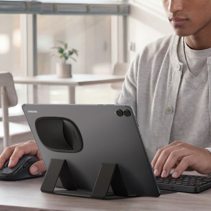 APP11227 - Laptop/Tablet Mouse Holder | LD220 in Black showing a tablet with the holder attached on the back, storing a mouse while the user works with a keyboard and mouse at a desk.