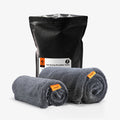 ACP11389 - Spigen CC100 Car Drying Microfiber Towel 2-pack packaging bag next to two rolled gray towels with orange tags