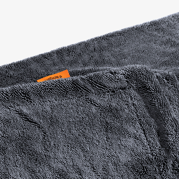 ACP11389 - Close-up of the folded edge of a gray Spigen microfiber car drying towel with an orange brand tag