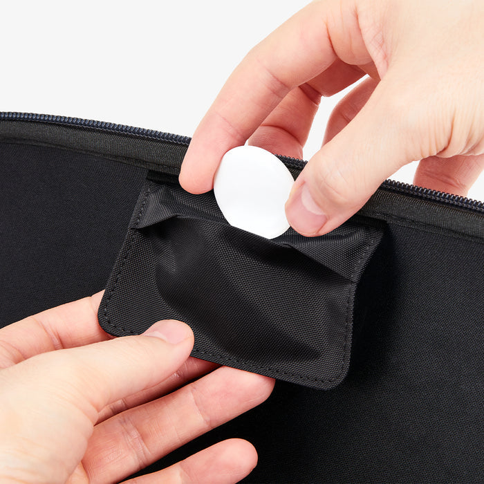 AGP10204 - Nintendo Switch 2 Klasden Pouch Renewed in Charcoal Gray showing a person holding the AirTag placing it inside a small pocket