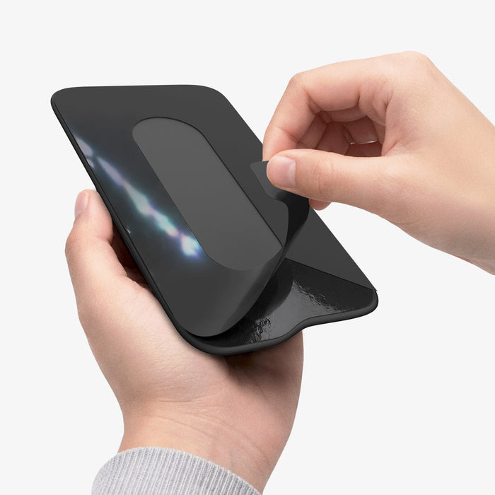 APP11228 - SSD/HDD Holder | LD221 in Black showing hands peeling adhesive backing with flexible fabric pouch stretching open for SSD insertion
