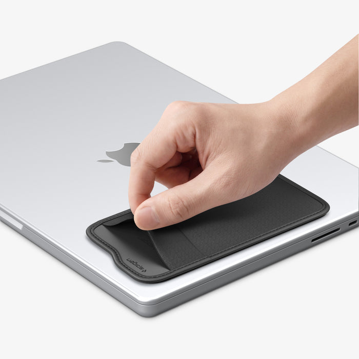APP11228 - SSD/HDD Holder | LD221 in Black showing hand lifting from MacBook lid surface demonstrating repositionable adhesive attachment on Apple laptop
