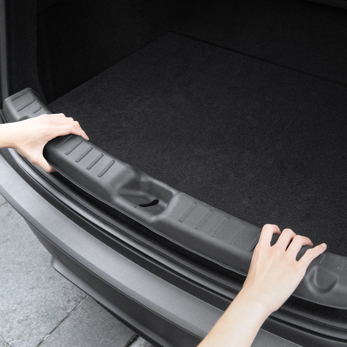 ACP09759 - Tesla Model Y Juniper Trunk Sill Guard | TG100-YJ in black showing someone installing the guard into the trunk