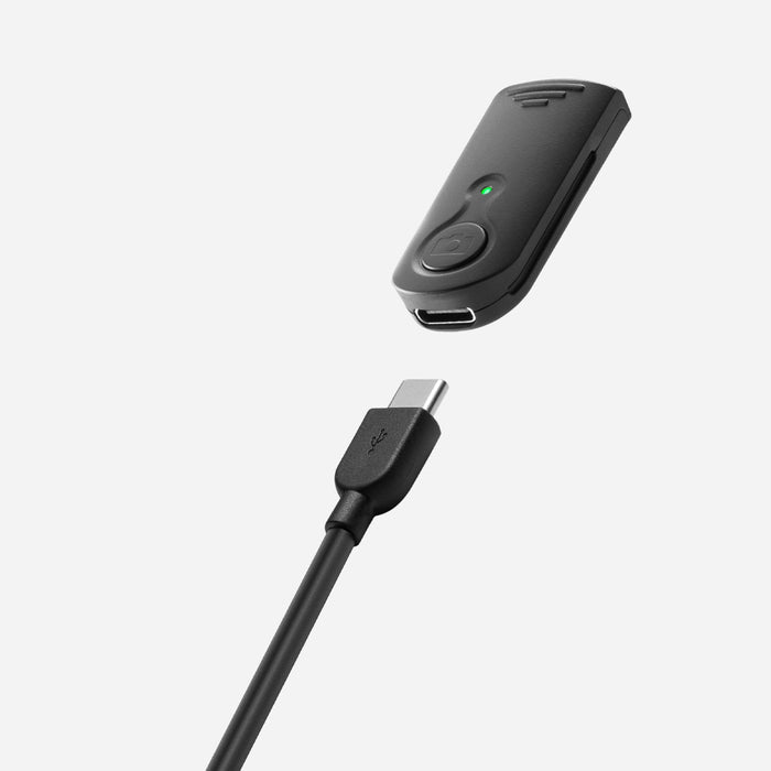 AMP07659 - Tripod Selfie Stick (Mag Fit) | S580W in Black showing the Bluetooth remote of the S580W selfie stick with USB-C charging port and indicator light, alongside a USB-C charging cable against a light gray background.