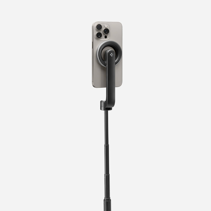 AMP07659 - Tripod Selfie Stick (Mag Fit) | S580W in Black showing the back of an iPhone attached magnetically to the S580W selfie stick via the MagFit mount, with the stick fully extended against a light gray background.