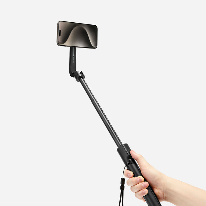 AMP07659 - Tripod Selfie Stick (Mag Fit) | S580W in Black showing a hand gripping the S580W selfie stick in extended handheld mode with an iPhone mounted at the top in landscape orientation against a light gray background.