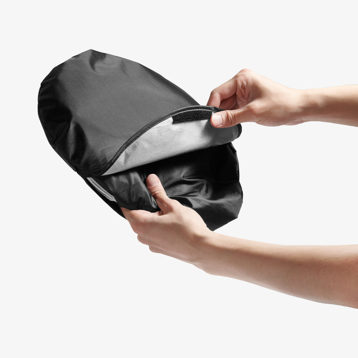 ACP11459 - Universal CryoShade UO260 S showing hands opening velcro closure on black storage pouch to insert folded sunshade
