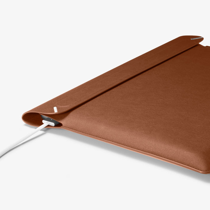 AFA06416 - Spigen Valentinus MacBook Sleeve side profile showing slim leather design with device inside and charger connected